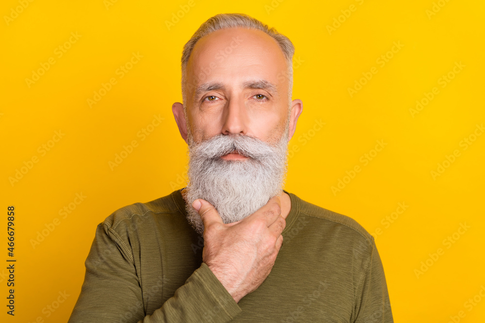 Photo of attentive serious age gentleman wear khaki shirt arm chin isolated yellow color background Photo of attentive serious age gentleman wear khaki shirt arm chin isolated yellow color background
