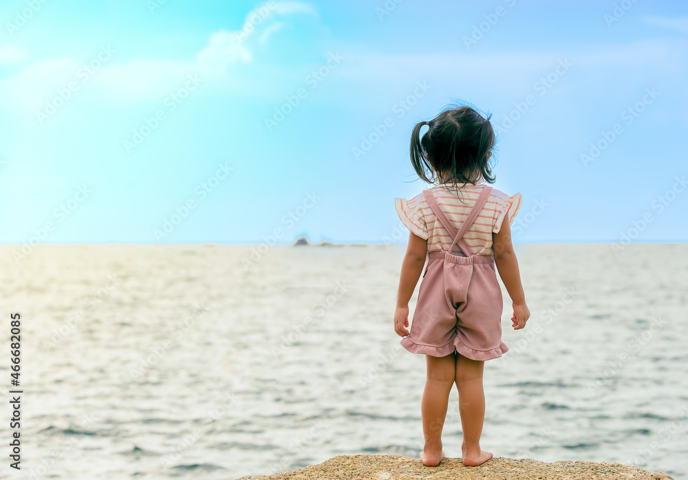 Naklejka premium An image child looking to turn around the sea in holiday the outdoor vacation day ocean with blue sky for the background as motion happiness.