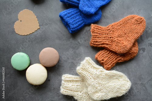 Small woolen handmade baby socks, on gray background