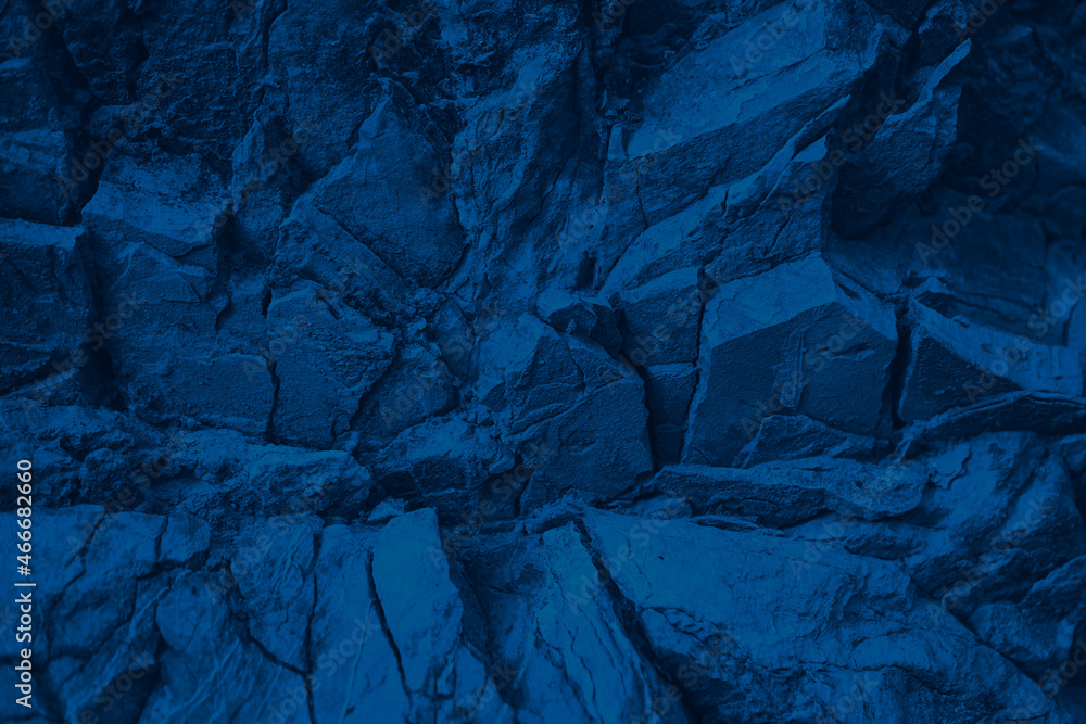 Blue rock texture. Toned mountain surface. Close-up. Navy blue  grunge background for design. Crumbled layers.