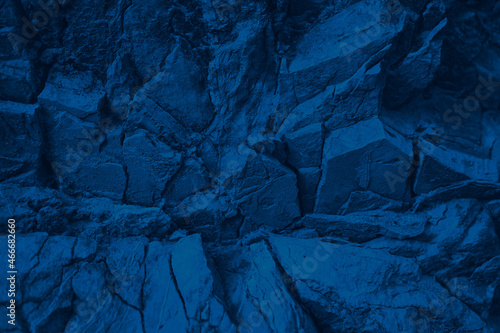 Blue rock texture. Toned mountain surface. Close-up. Navy blue grunge background for design. Crumbled layers.