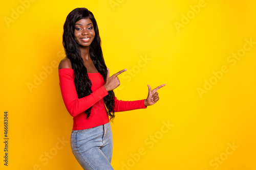 Photo of cute adorable dark skin lady wear off-shoulders top pointing fingers empty space isolated yellow color background