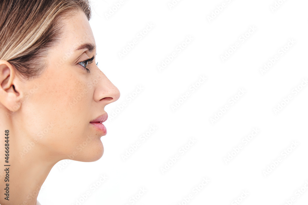 Portrait of a beautiful blonde with natural makeup on a white background. Profile. Studio shot. Portrait of a beautiful blonde with natural makeup on a white background. Profile. Studio shot.