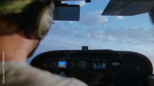 Man flying a small Cessna plane during the sunrise.