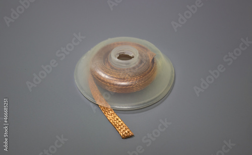 Desoldering braid or desoldering wick. Pre-fluxed copper braid that is used to remove solder, which allows components to be replaced and excess solder to be removed photo