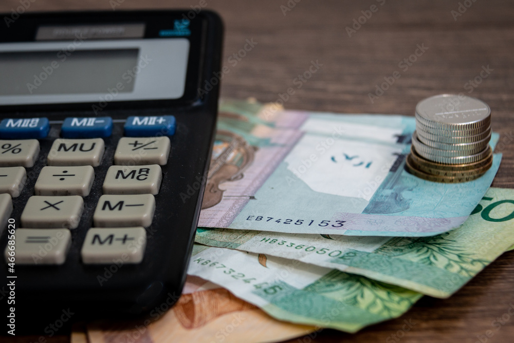 Belarusian money and calculator on a blurred wooden background. Belarusian currency. Belarusian money. Belarusian coins. Financial reports. Blurred background. Belarusian money and calculator on a blurred wooden background. Belarusian currency. Belarusian money. Belarusian coins. Financial reports. Blurred background.