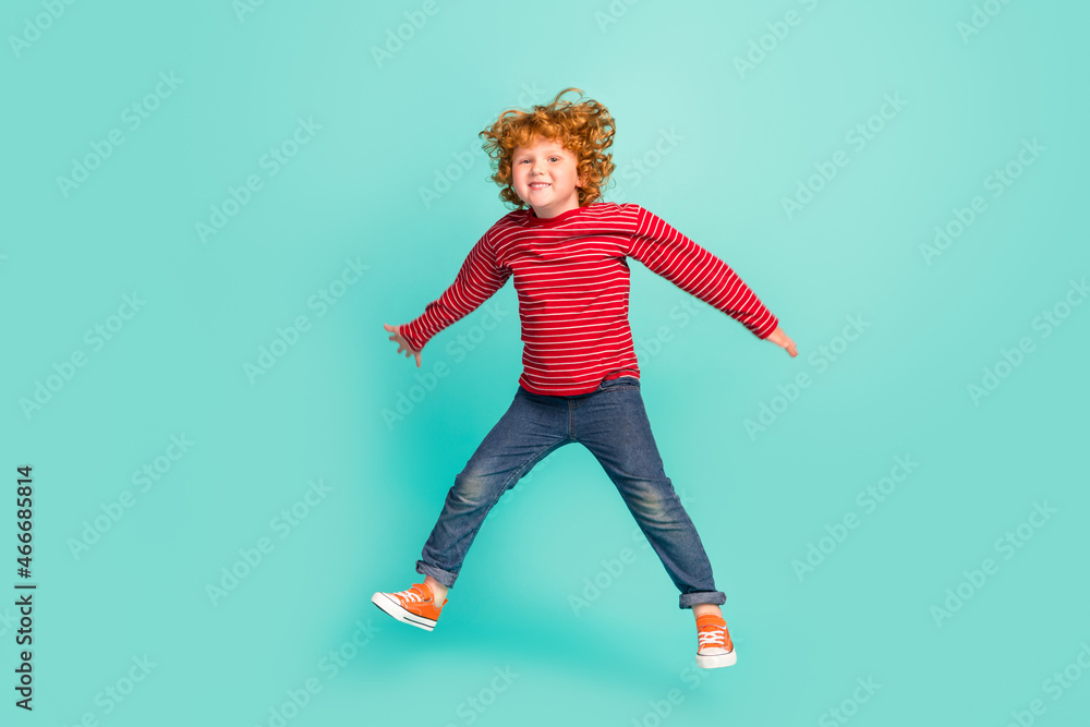 Full size photo of funky small boy jump wear shirt jeans sneakers isolated on blue background