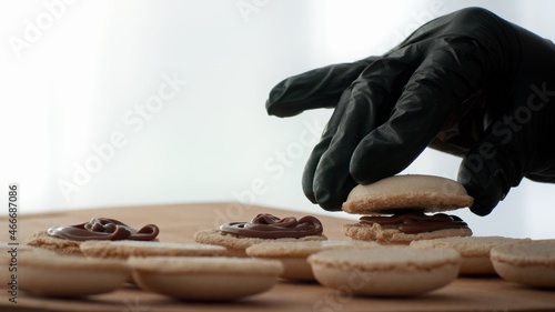 фотографія Pastry Chef Baking Macarons Cookies In Kitchen Indoors, Closeup