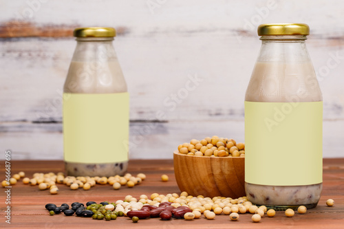 Healthy milk nourishment drink from organic beans extract in glass cup and bottle as advertising beverage product for natural vegan breakfast