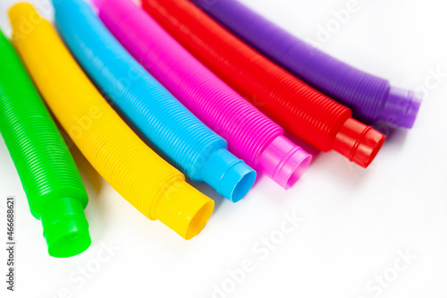 pop tube trending toy of 2021. anti-stress sensory figet plastic toy. multicolored bright tubes isolated on white background. copy space. top view. photo