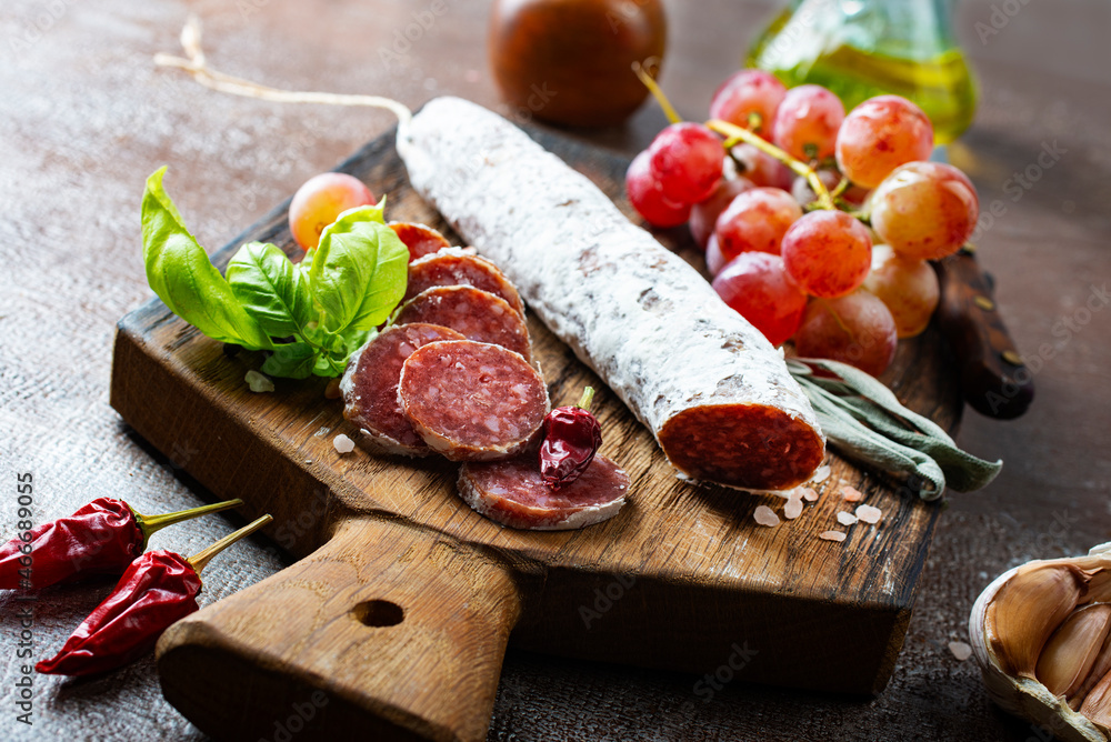 salami with spice on board, salami and fresh grape