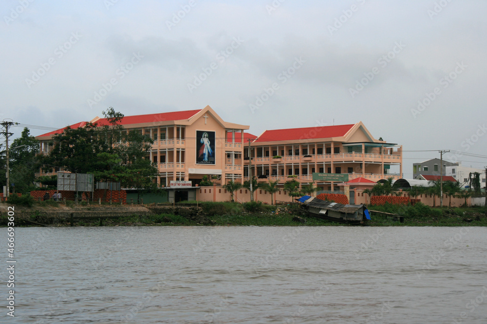 building (church ?) along a river at the mekong delta in vietnam building (church ?) along a river at the mekong delta in vietnam