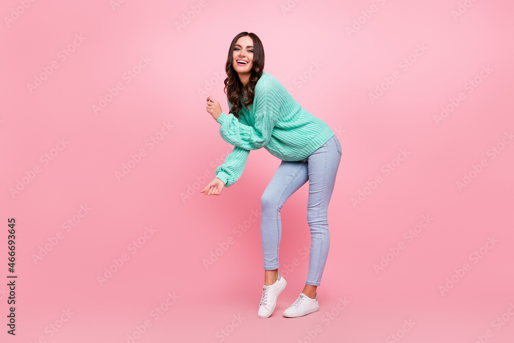 Full length profile photo of cool brunette young lady dance wear sweater jeans sneakers isolated on pink color background