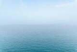 Abstract infinity sea view with small wave pattern and fog on horizon, clear sky in Puglia, Italy
