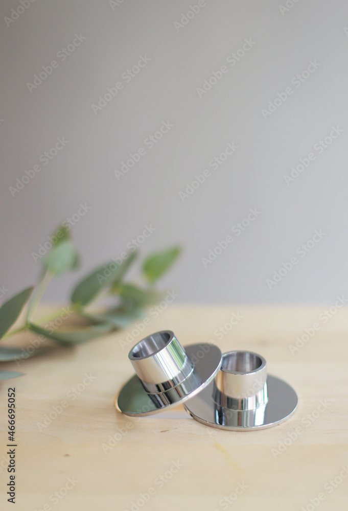 Small metal candlestick with flowers on wooden table. Small metal candlestick with flowers on wooden table.