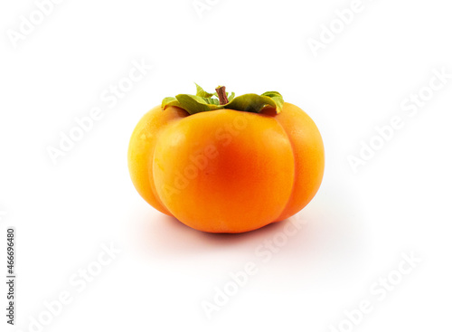 Photo of a ripe fuyu Asian persimmon with leaves and stem intact