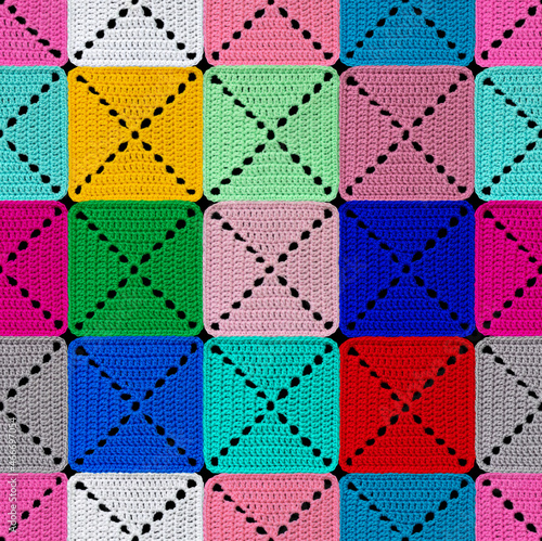 Bright patchwork seamless pattern. The geometric elements are crocheted from multi-colored acrylic yarn. Bright colors. photo