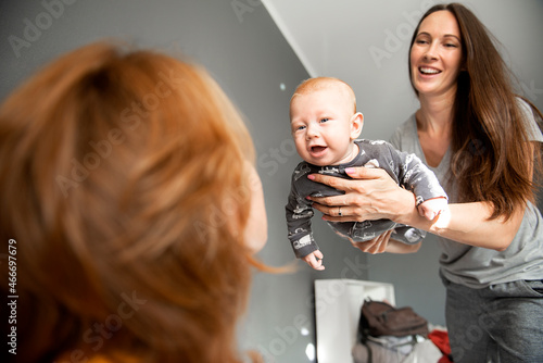 Portrait of a mother and grandmother smiling with baby indoors