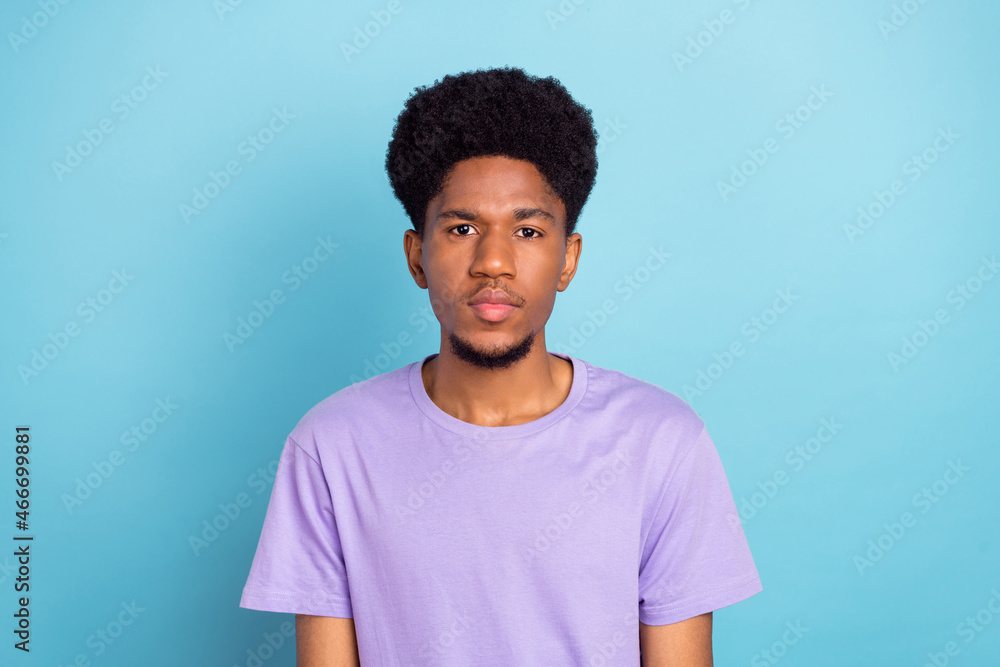 Photo of nice young brunet guy wear violet t-shirt isolated on blue color background Photo of nice young brunet guy wear violet t-shirt isolated on blue color background