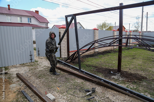 A worker makes a metal frame for a sliding gate.