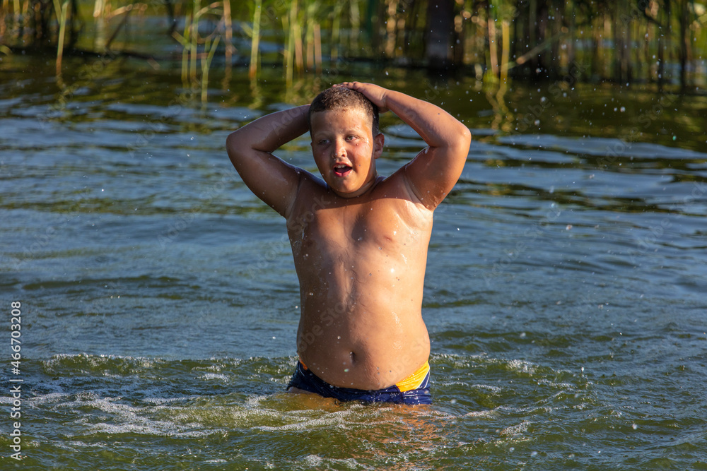 Fototapeta premium The boy bathes in the water