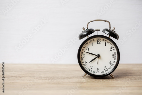 Vintage alarm clock on wooden table background and copy space for text. Activity, daily routine, morning, workout and Work life balance concept