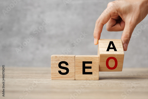 Hand flip SEA to SEO text wooden cube blocks on table background. Search Engine Optimization, Advertising, Idea, Strategy, marketing, Keyword and Content concept