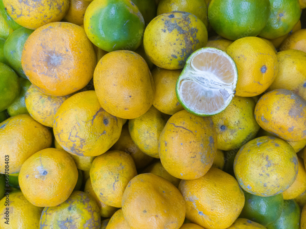 pile of oranges for sale with one peeled fruit as a sample pile of oranges for sale with one peeled fruit as a sample