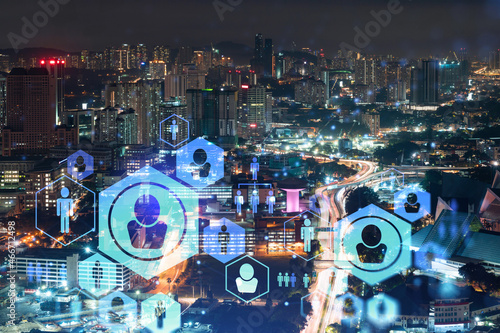 Glowing social media icons on night panoramic city view of Kuala Lumpur, Malaysia, Asia. The concept of networking and establishing new connections between people in businesses in KL. Double exposure.