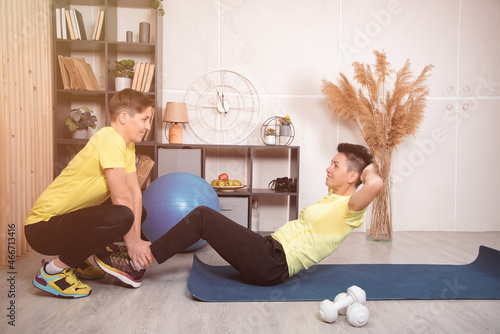 Two cute girls go in for sports together at home. Healthy lifestyle of two women.