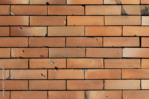 Old orange brick wall with holes and cracks background Fototapet