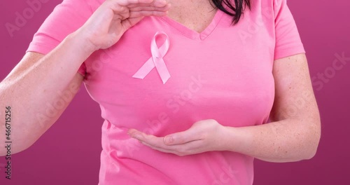 Wallpaper Mural Video of midsection of caucasian woman wearing pink cancer awareness ribbon, with pink background Torontodigital.ca