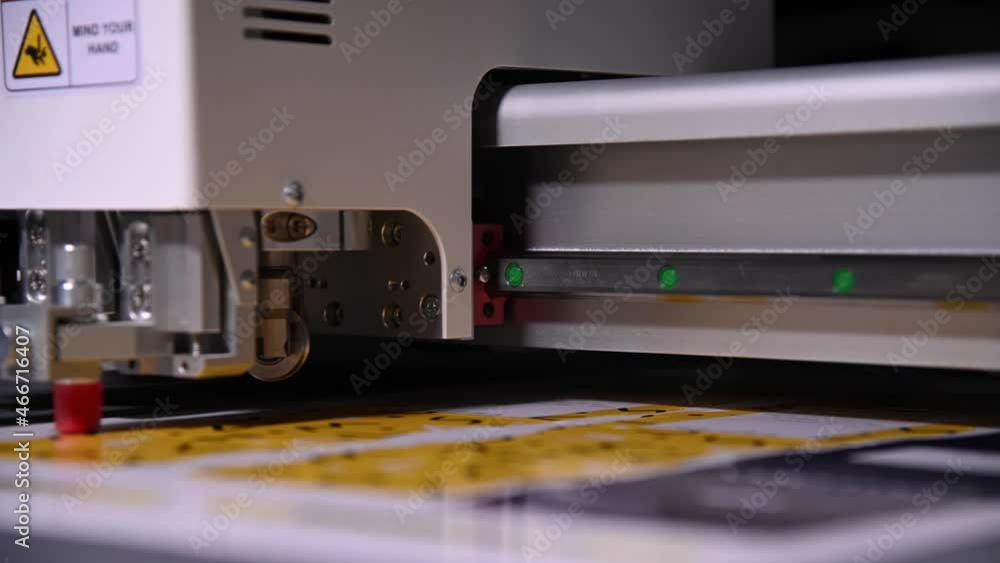 An industrial advertising plotter close-up cuts a template on the cardboard packaging for products. shallow depth of field in real time. Live camera An industrial advertising plotter close-up cuts a template on the cardboard packaging for products. shallow depth of field in real time. Live camera