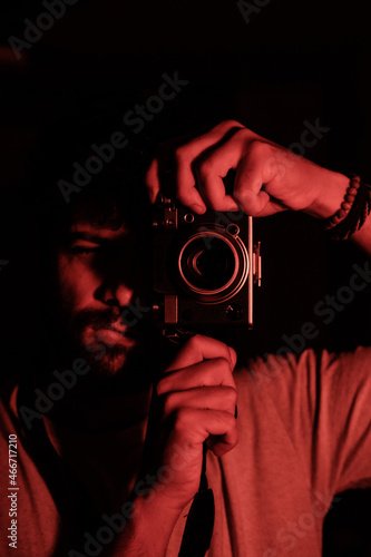 A proffesional photographer takes a self portrait with a retro camera.