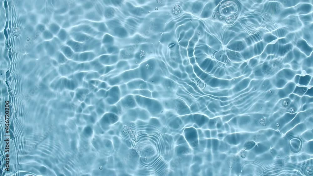 Water surface texture top view. Water waves blue colored. Sun and shadows. Pure blue water with reflections sunlight in slow motion. Motion clean swimming pool ripples and wave. 4k. High quality 4k