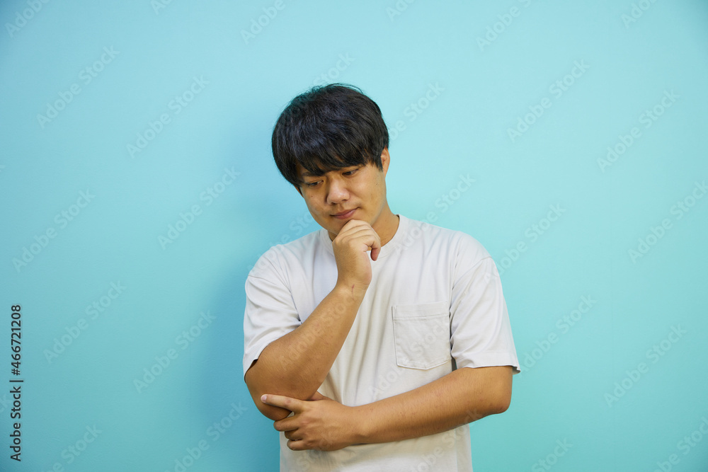 悩むポーズをする白シャツを着たアジア人男性 悩むポーズをする白シャツを着たアジア人男性