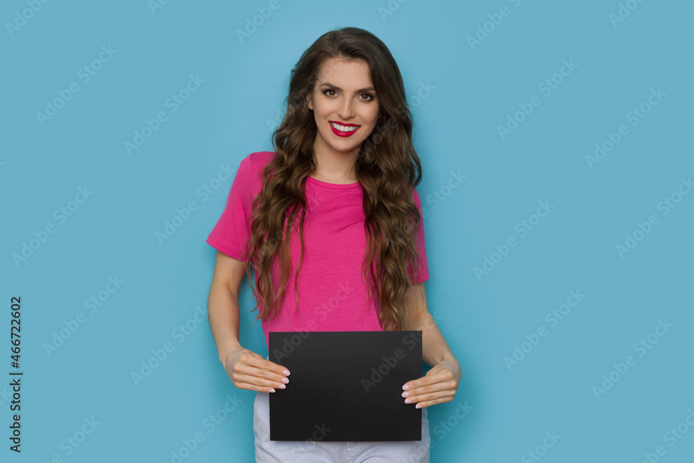 Beautiful smiling woman is posing with black sheet of paper Beautiful smiling woman is posing with black sheet of paper