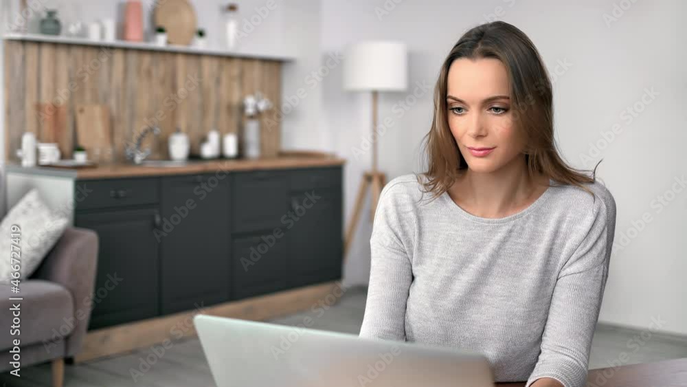 Smiling confident blonde freelancer woman working remotely use laptop sitting table kitchen Smiling confident blonde freelancer woman working remotely use laptop sitting table kitchen
