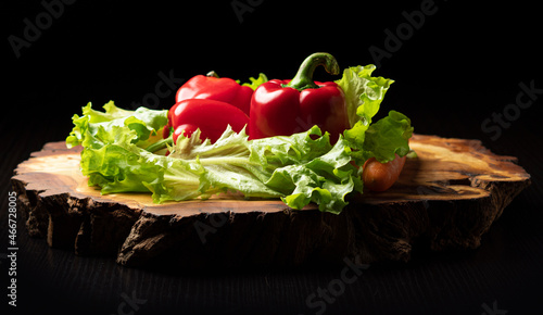 Obraz na plátně Bulgarian pepper lettuce leaves and carrots on a wooden part-time