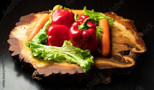 Fotografie Bulgarian pepper lettuce leaves and carrots on a wooden part-time