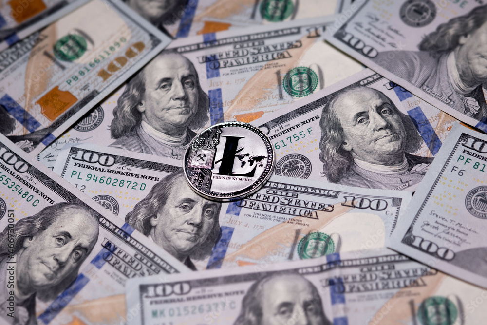 Fototapeta premium Silver Litecoins coin and US banknotes of one hundred dollars. Digital cryptocurrency close-up. Exchange, bussiness, commercial. Profit from mining crypt currencies