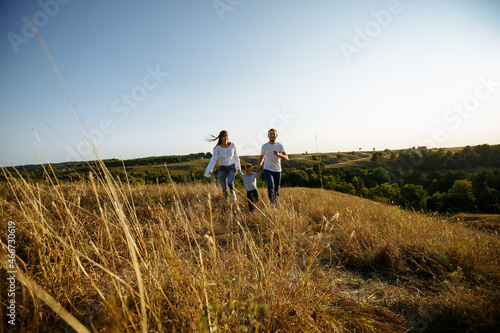 couple walking in the countryside with their little son