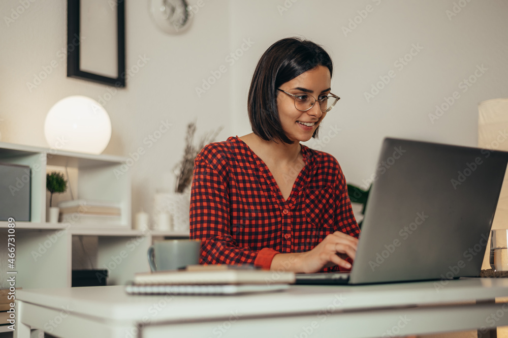 Beautiful woman using a laptop while working from home Beautiful woman using a laptop while working from home