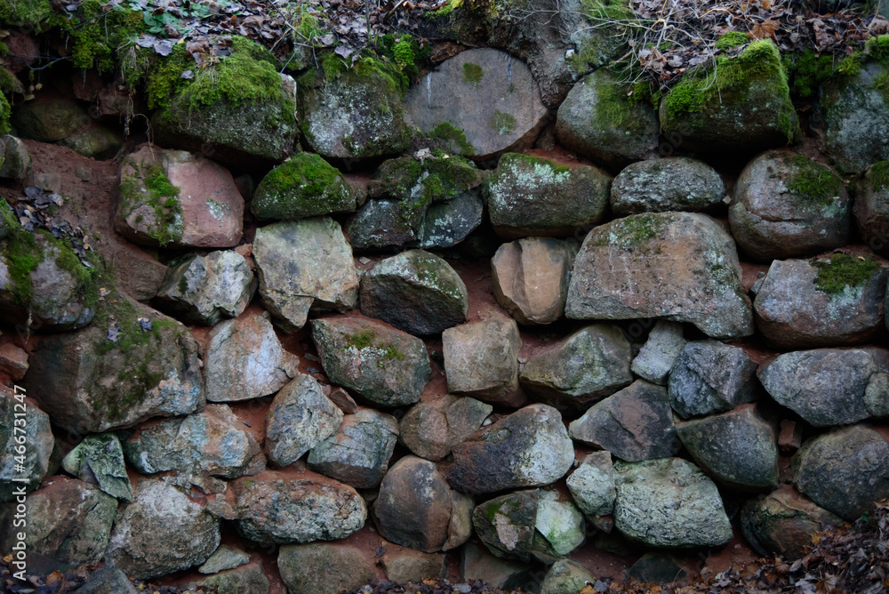 A beautiful stone wall in a nature park in the middle of the forest in autumn