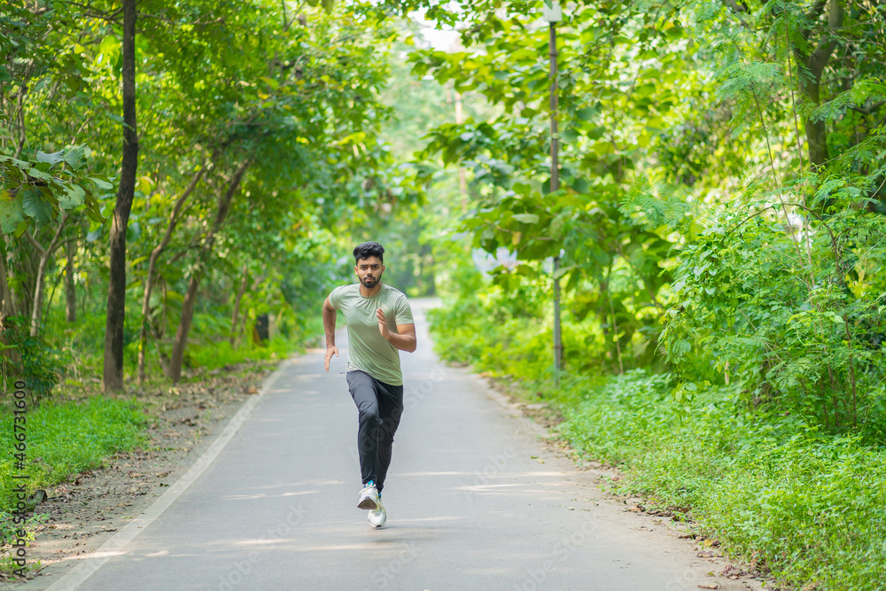 Young man running in the park at morning, also known as jogging or morning walk Young man running in the park at morning, also known as jogging or morning walk