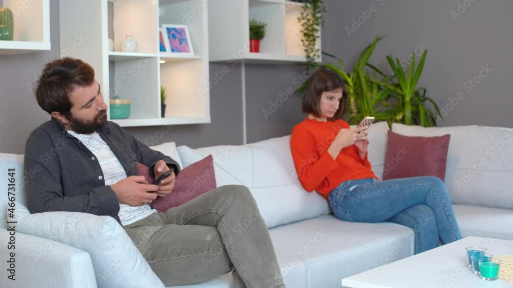Husband and wife hanging out at home. Nervous glances. Phone addiction. Man doing head exercise. Husband and wife hanging out at home. Nervous glances. Phone addiction. Man doing head exercise.