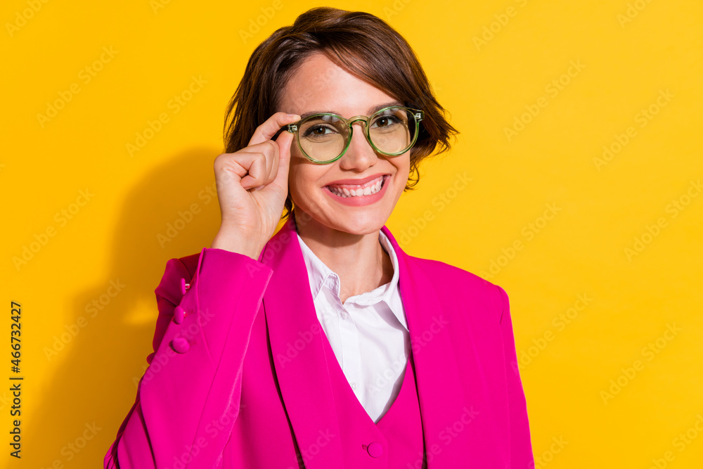 Portrait of attractive cheerful content intelligent girl touching eyewear isolated over vibrant yellow color background Portrait of attractive cheerful content intelligent girl touching eyewear isolated over vibrant yellow color background