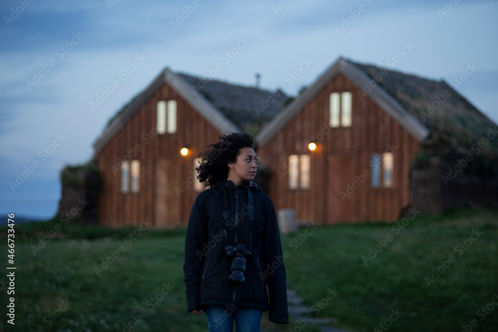 Mujer saliendo de una casa en ( fjalladýrð, islandia)