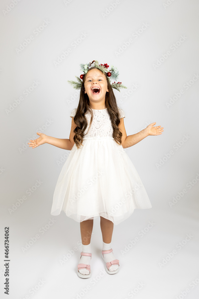full-length portrait of laughing, joyful woman in elegant white dress and Christmas wreath, isolated on white background with copy space. full-length portrait of laughing, joyful woman in elegant white dress and Christmas wreath, isolated on white background with copy space.