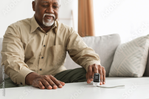 Ill Older Man With Pulse-Oxymeter Measuring Oxygen Saturation At Home photo